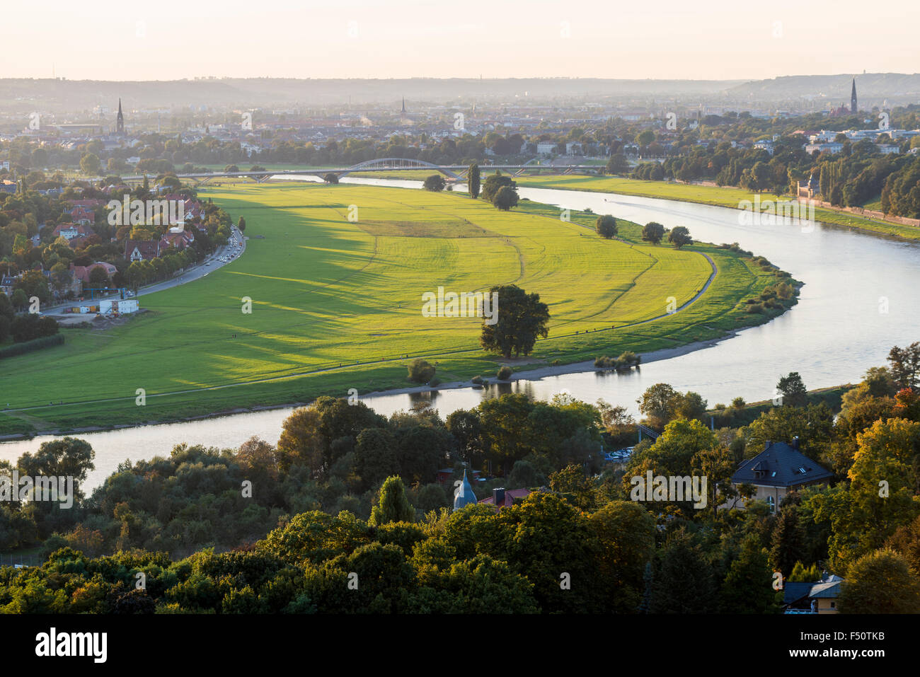 Die grünen Wiesen am Ufer des Flusses Elbe in der Nähe von Dresden mit der neuen Brücke Waldschlößchenbrücke in der Ferne Stockfoto