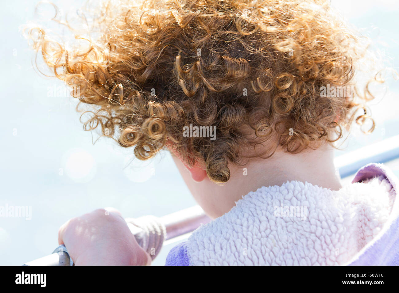 Lockigen Haaren junges Mädchen über ein Geländer Stockfoto