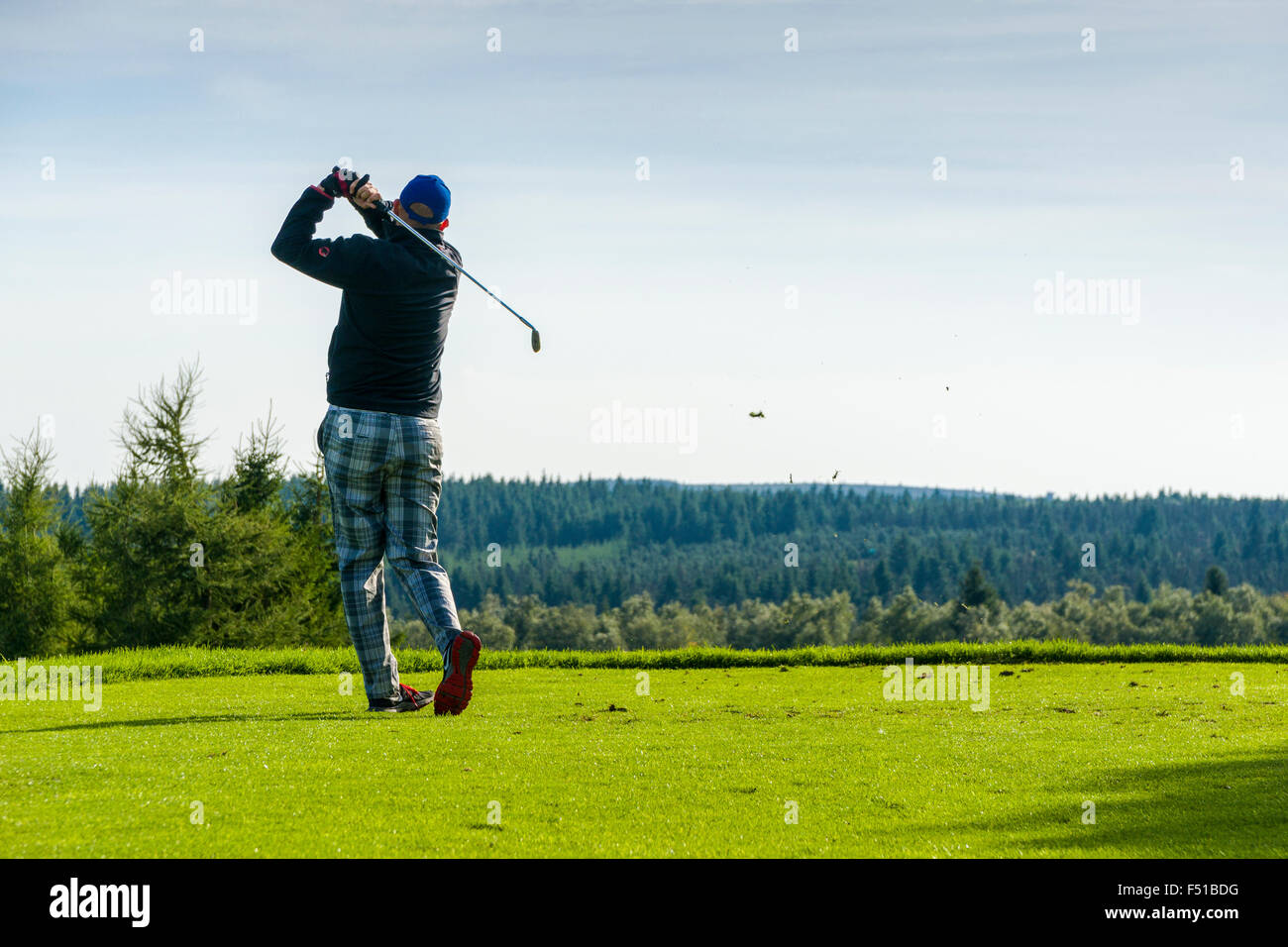 Ein Mann spielt Golf auf der grünen Wiese Stockfoto