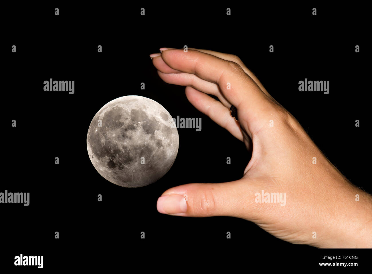 Die Hand einer Frau ist den Mond über einem schwarzen Himmel fangen. Konzeptbild für Bestrebungen, träumt, wird Unmöglichkeiten, ha Stockfoto