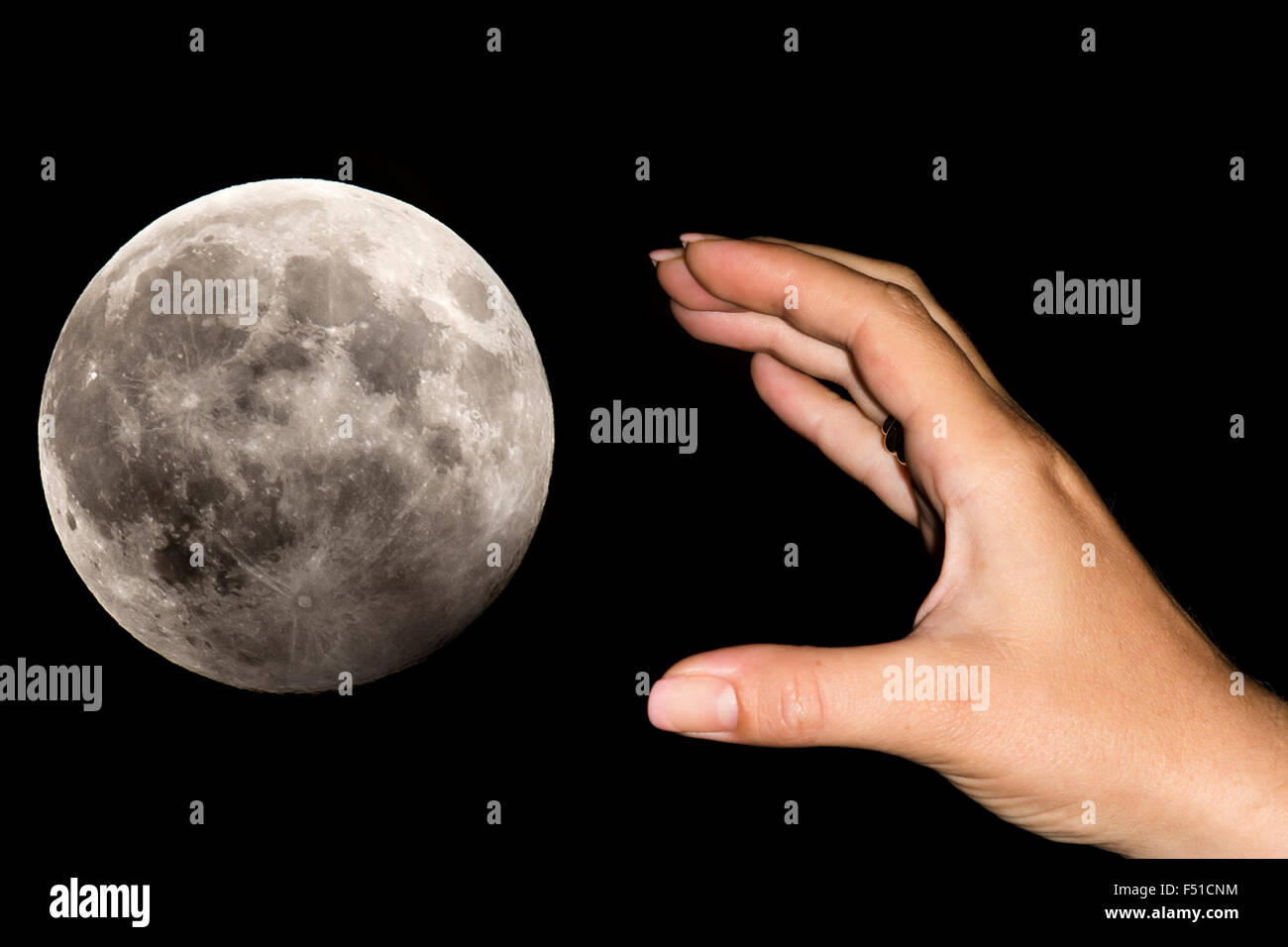 Die Hand einer Frau übernimmt ein schwarzer Himmel den Mond. Konzeptbild für Bestrebungen, Tagträume, Willen Unmöglichkeiten, haben Stockfoto
