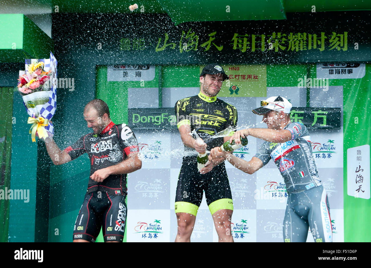 Dongfang, Chinas Provinz Hainan. 26. Oktober 2015. Tino Thomel (C) von RTS-SANTIC RACING TEAM sprüht Champagner während der Verleihung der 7. Etappe von 2015 Tour von Hainan internationalen Radsport Straßenrennen in DONGFANG, Süd-China Provinz Hainan, am 26. Oktober 2015. Tino Thomel aus Rts-Santic Racing Team gewann die 7. Etappe. Sacha Modolo aus Lmapre-Merida noch immer die grüne und gelbe Trikots, Julien El Fares von Team Marseille-13-Ktm hielt das Bergtrikot, Ma Guangtong aus Hengxiang Cycling Team hielt das blaue Trikot. Bildnachweis: Yang Guanyu/Xinhua/Alamy Live-Nachrichten Stockfoto