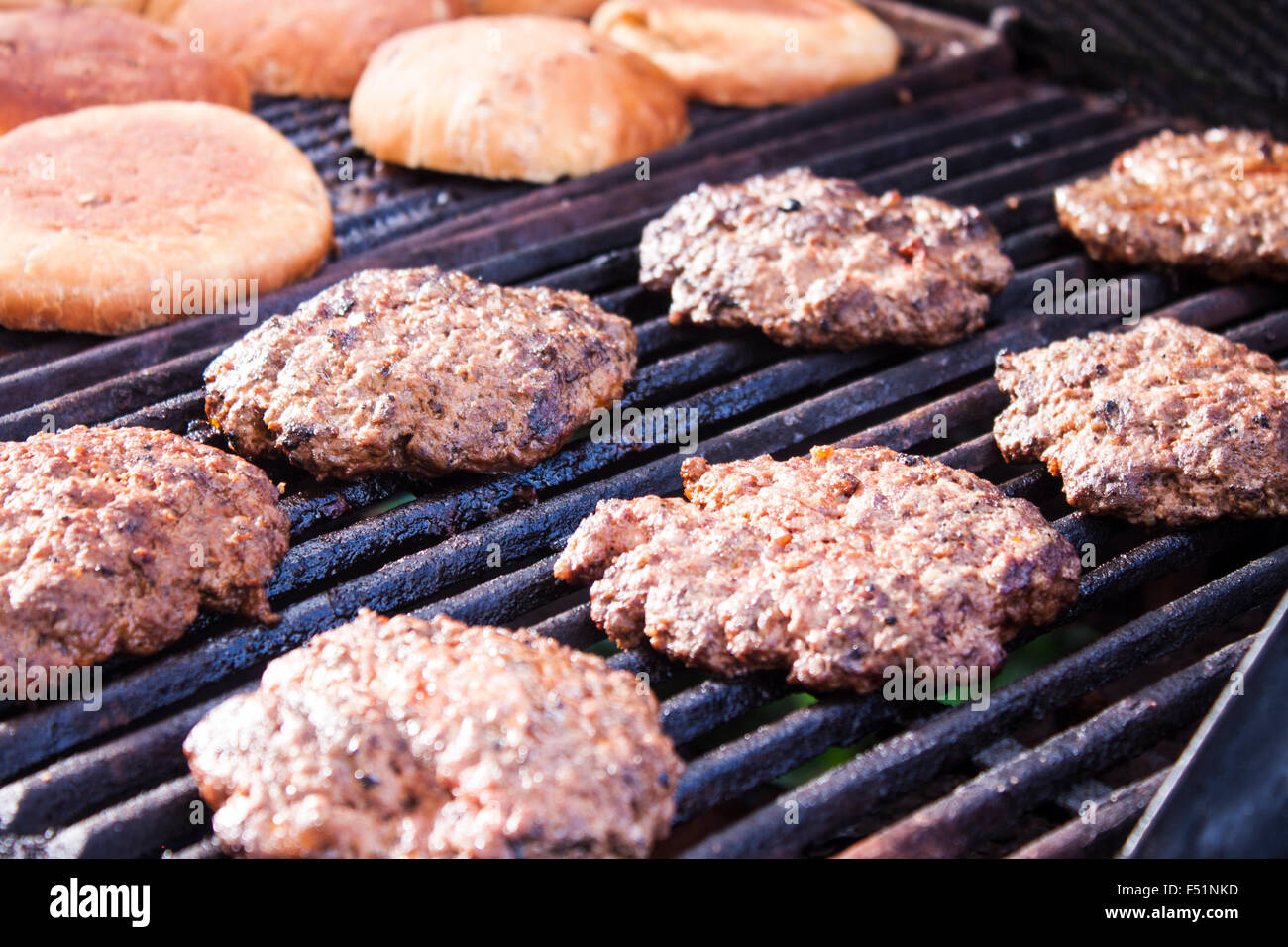 Hamburger Rinder und Brötchen auf ein Gas-Grill Grillen Stockfoto