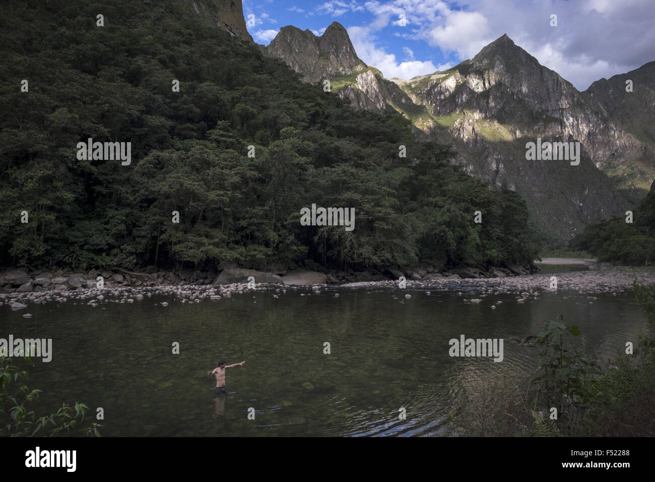 Ein Tourist badet im Fluss Urubamba neben Berg wo befindet sich die Stadt Machupicchu Stockfoto