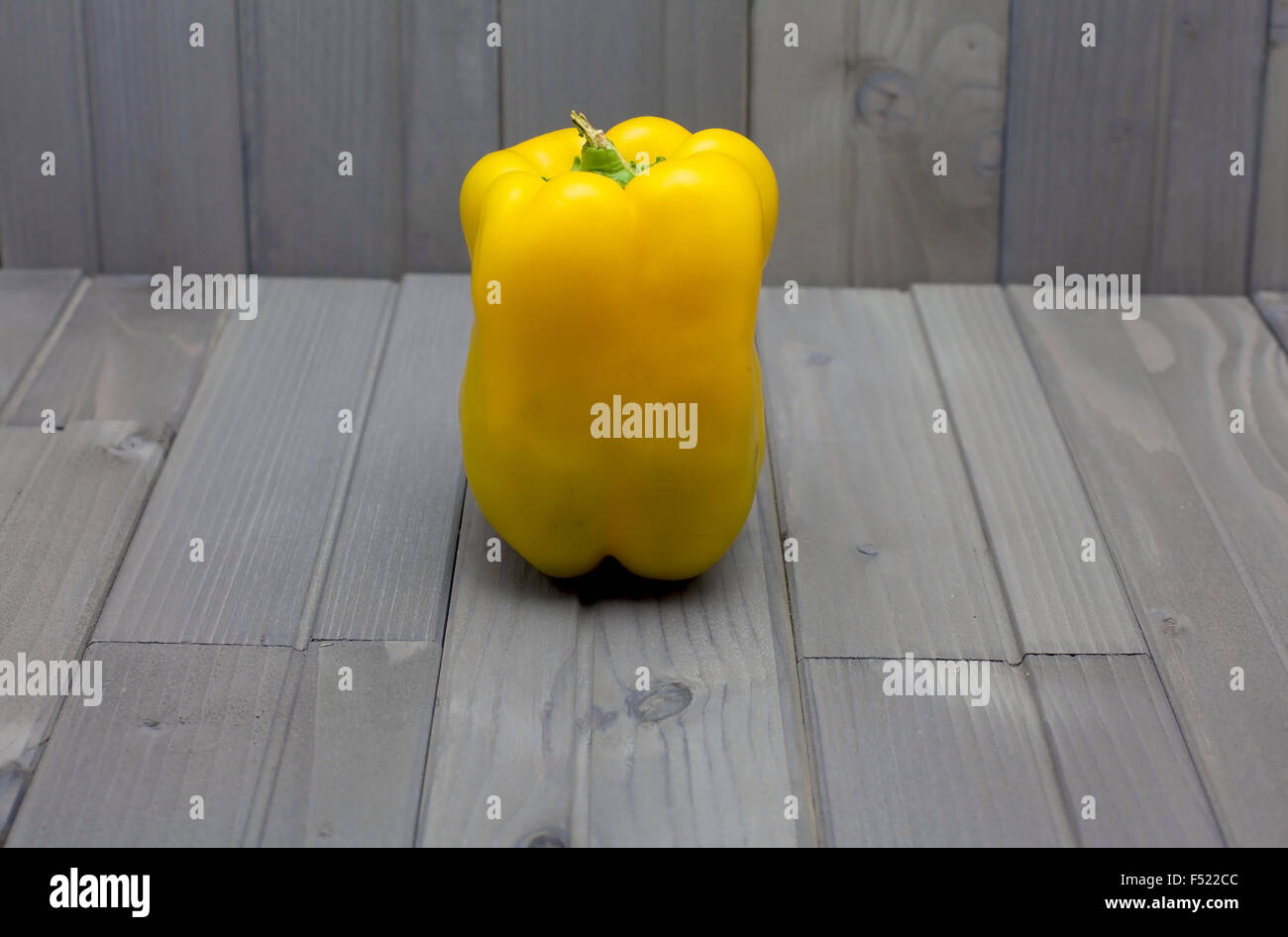 eine gelbe Paprika auf ein graues Holz Tisch Stockfoto