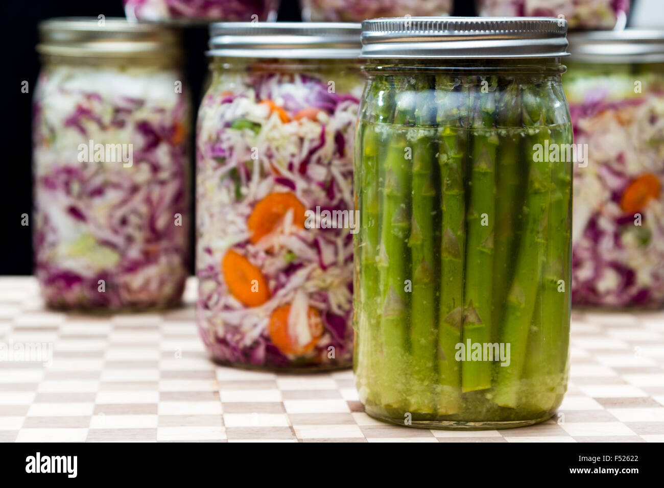 Hausgemachte fermentierte Spargel mit Gläser mit Kohl und Karotten im Hintergrund Stockfoto