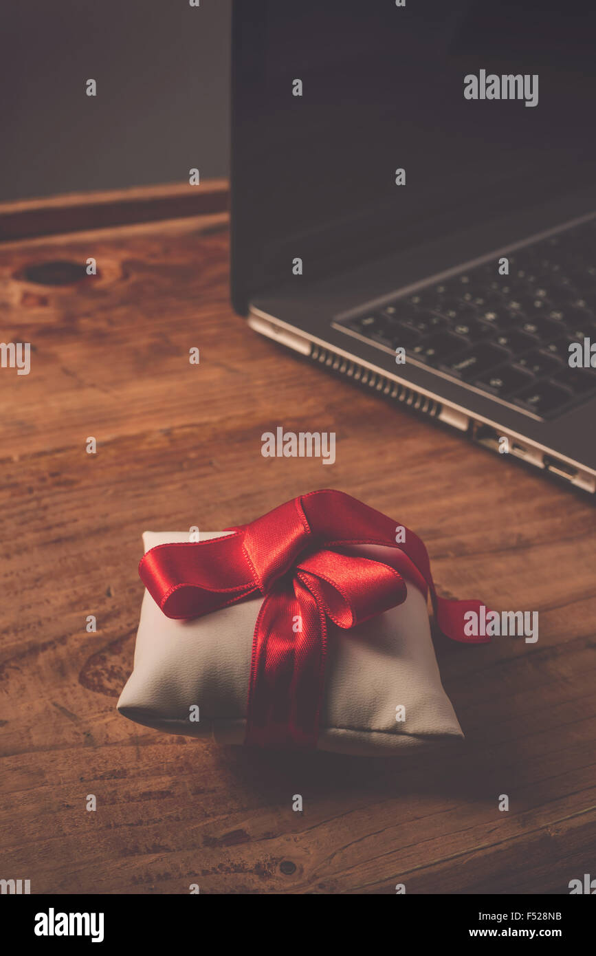Büro-Jubiläums-Überraschung für Mitarbeiter, gewickelt auf hölzernen Schreibtisch mit Laptop-Computer im Hintergrund, Retro-getönten vorhanden Stockfoto