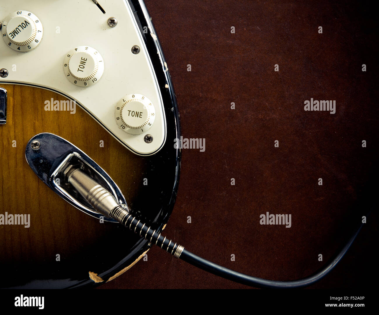 Körperteil Gitarre angeschlossen Kabel Detail auf hölzernen Hintergrund Vintage-look Stockfoto