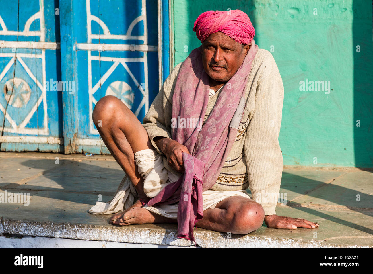 Mann aus Rajasthan sitzen vor Haus auf Bürgersteig Stockfoto