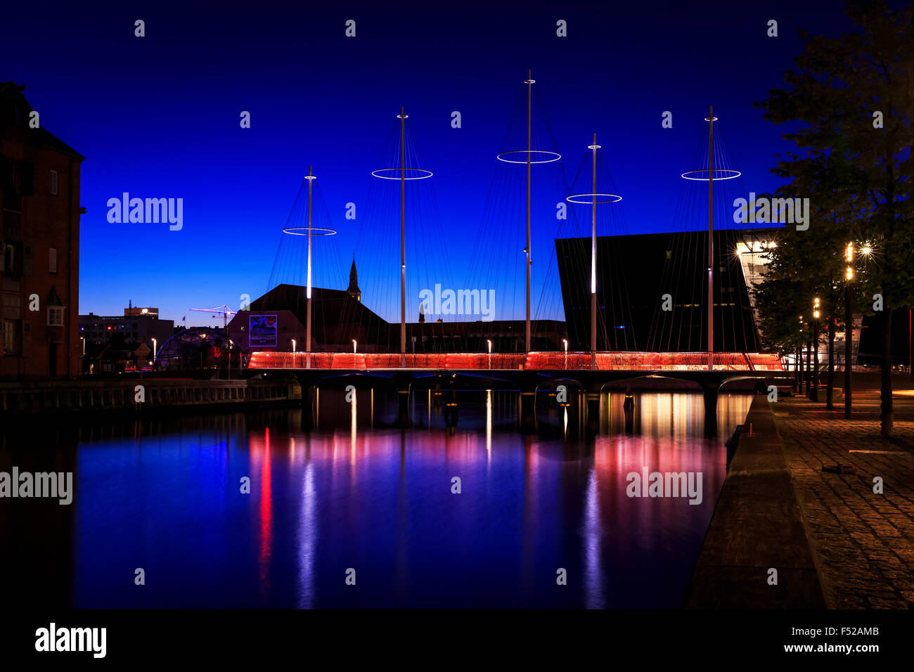 Die Kreis-Brücke über Christianshavn Kanal bei Sonnenuntergang, The Black Diamond im Hintergrund, Kopenhagen, Dänemark Stockfoto