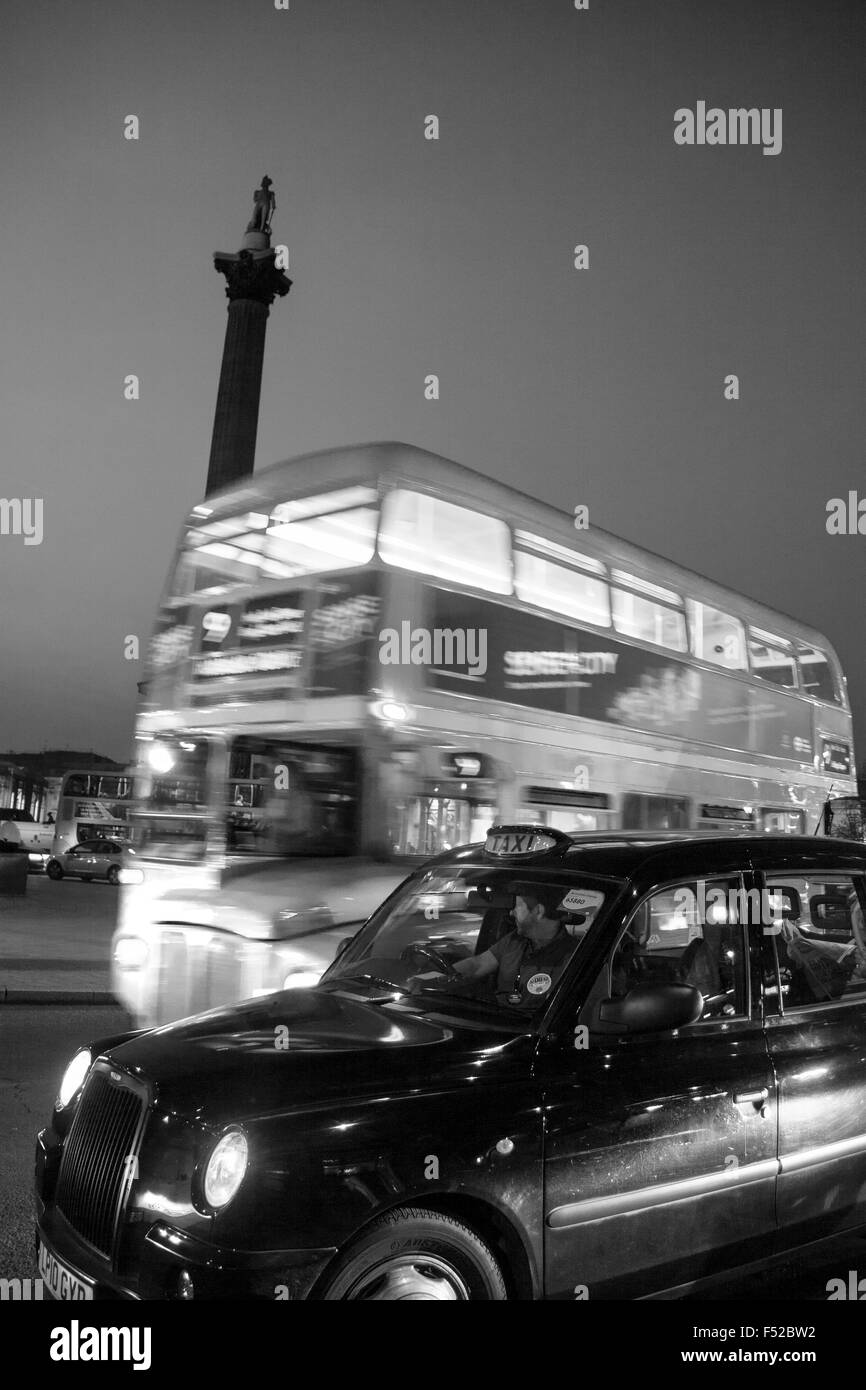 Trafalgar Square traditionellen Routemaster Bus und schwarzes Taxi Cab vorbei Nelson Säule in der Nacht London England UK Stockfoto