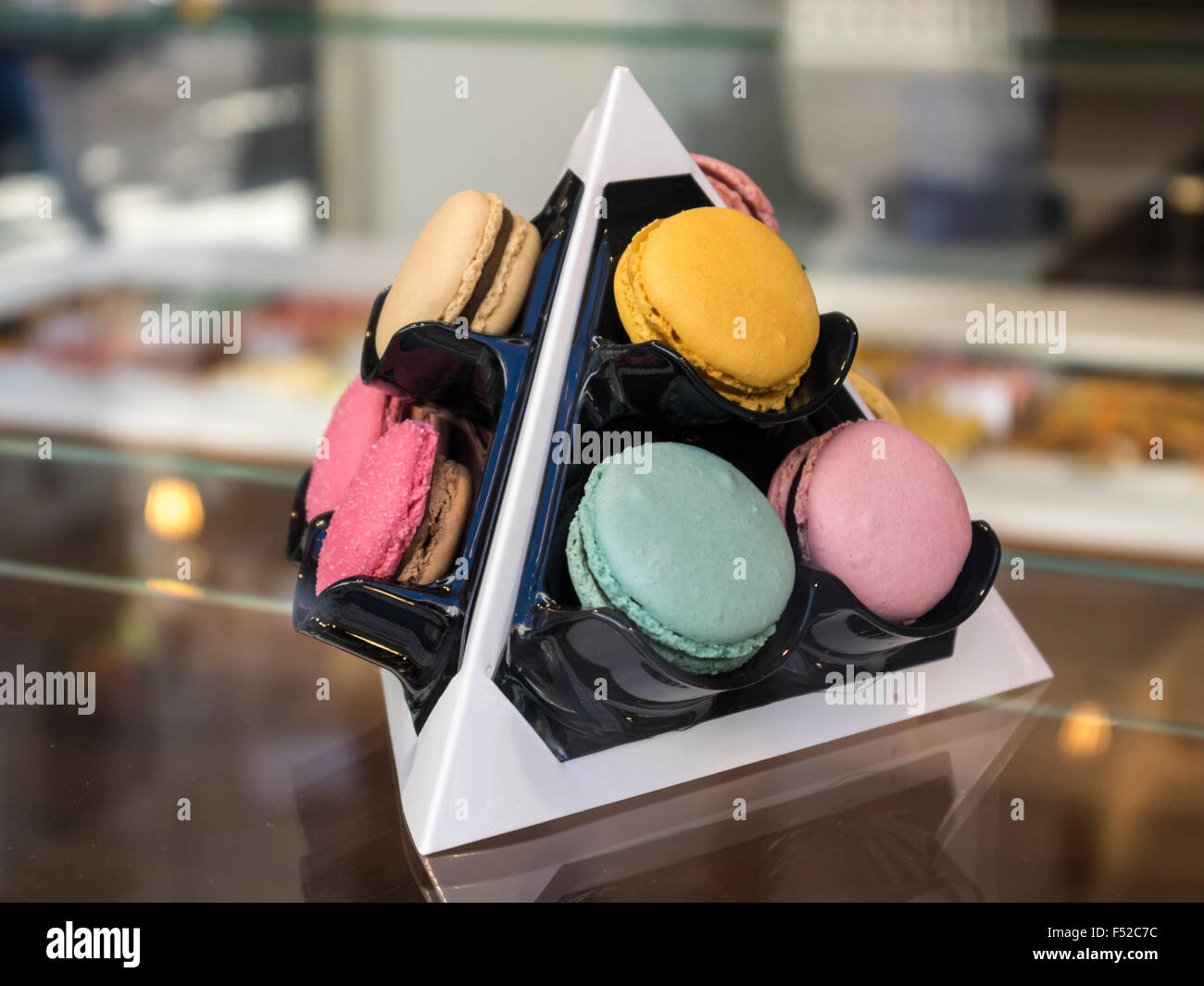 Verschiedenen Macarons in verschiedenen Farben auf einem Tetraeder-förmigen Display. Stockfoto