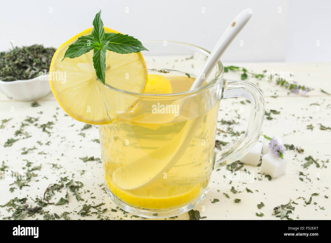 Pfefferminztee mit Zitrone und eine frische Minze Pflanze auf den Tisch Stockfoto