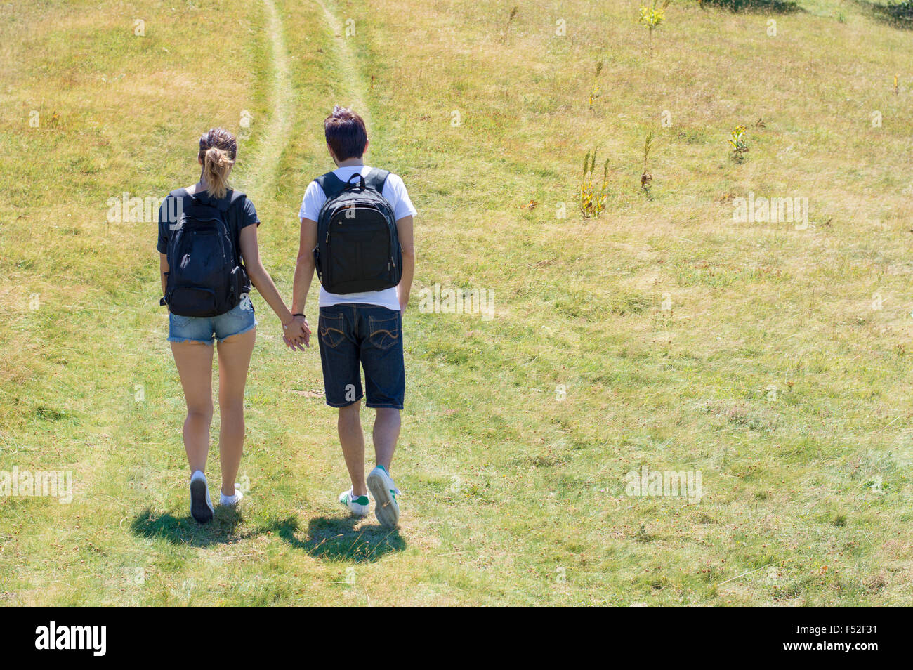 Paar der Wanderer unter den Weg auf den Berg mit Rucksäcken auf Stockfoto