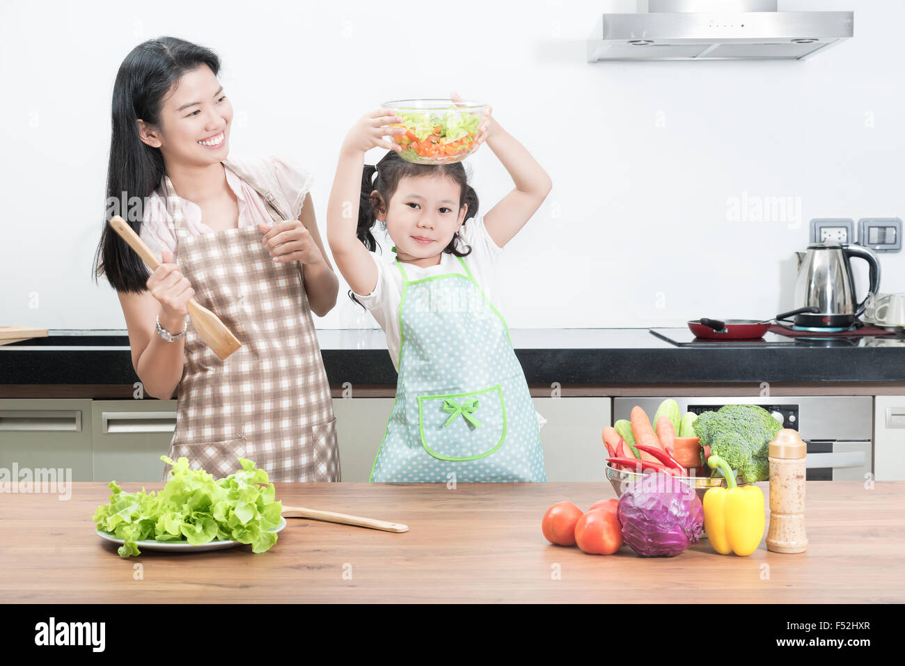 Familie, Kinder und glückliche Menschen Konzept - Asiatisch Kochen in der Küche zu Hause Tochter von Mutter und Kind Stockfoto