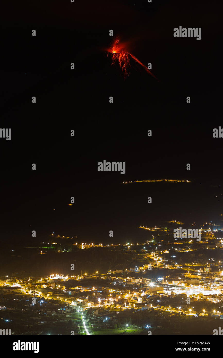 Tungurahua Vulkan Explosion in der Nacht mit der Stadt Patate im Vordergrund. Stockfoto