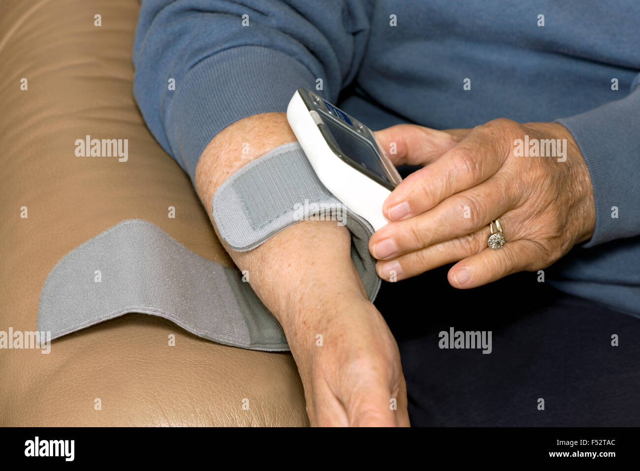 Ältere Patienten stellt Blutdruckmessgerät am Handgelenk, Bluthochdruck zu messen. Stockfoto
