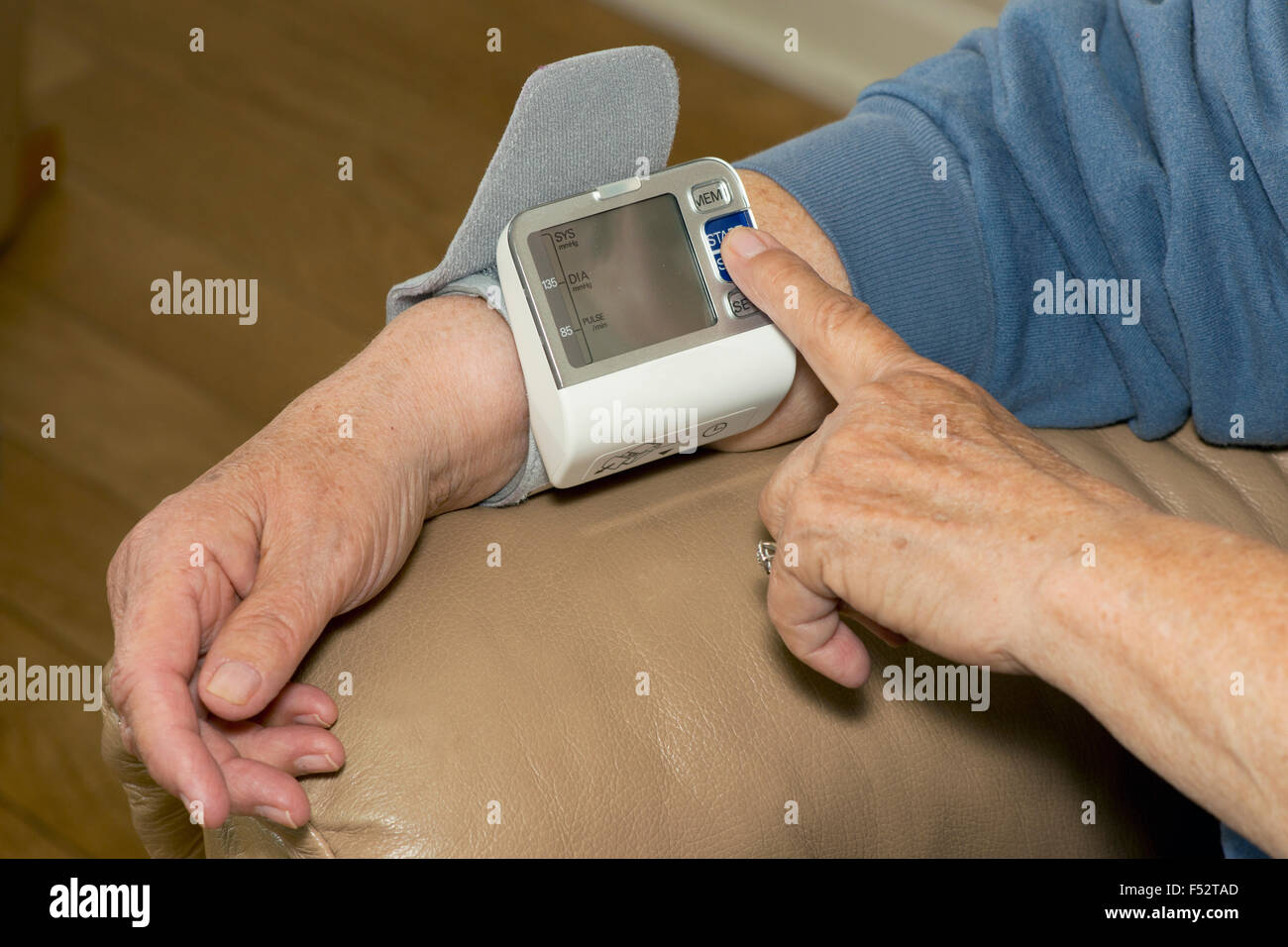 Ältere Patienten stellt Blutdruckmessgerät am Handgelenk, Bluthochdruck zu messen. Stockfoto