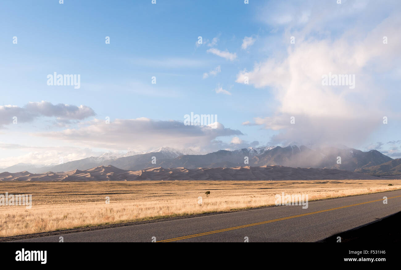 Landschaftsfoto zeigt Autobahn bis Sanddünen mit Bergen im Hintergrund Stockfoto