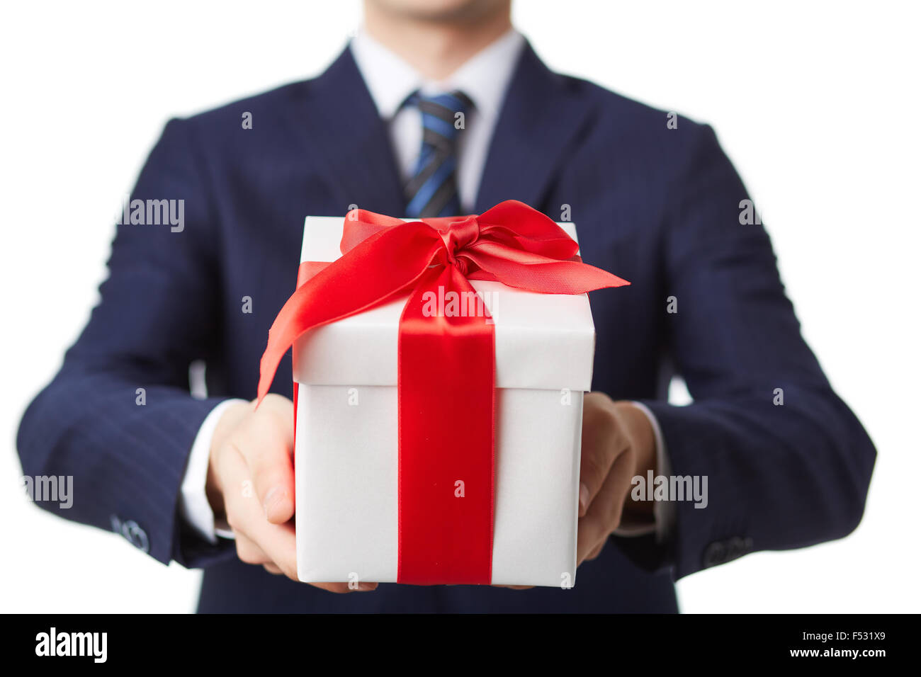 Junger Geschäftsmann, so dass Paket mit Geschenk Stockfoto
