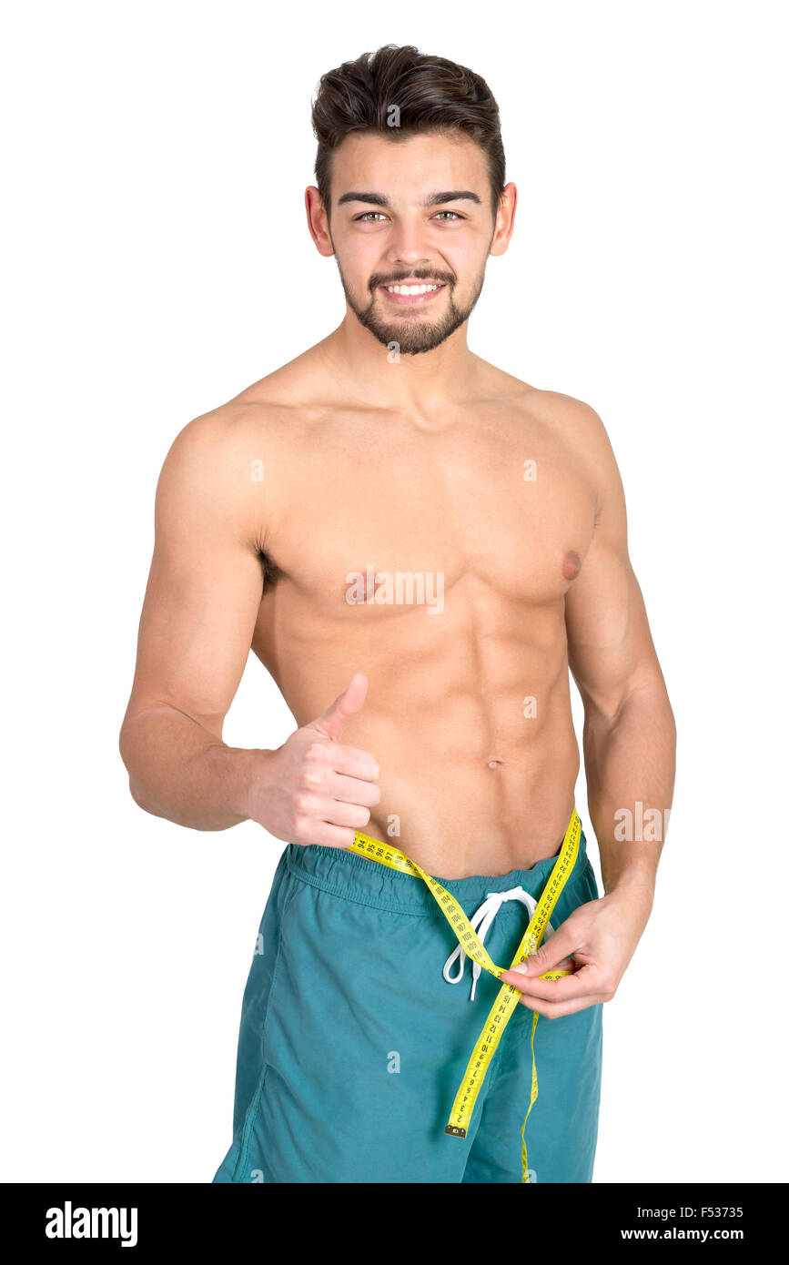 Muskulös und Fit junger Mann mit großen Bauchmuskeln und Maßband isoliert in weiß Stockfoto