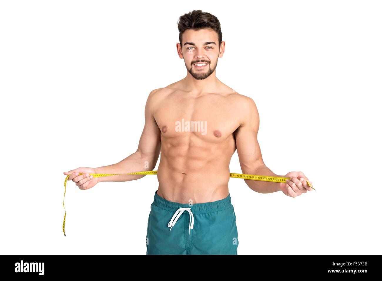 Muskulös und Fit junger Mann mit großen Bauchmuskeln und Maßband isoliert in weiß Stockfoto