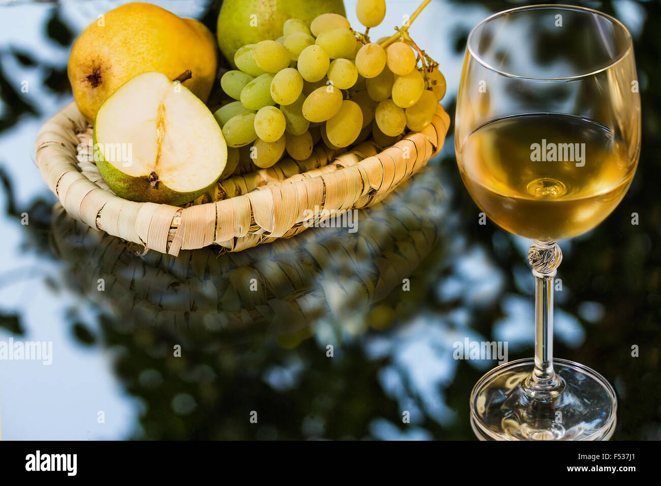 Reife saftige appetitlich Trauben, Birnen und Glas Wein auf Spiegel-Hintergrund Stockfoto