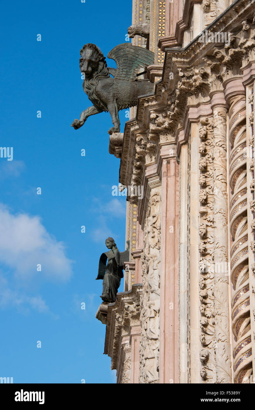 Italien, Umbrien, Orvieto. Die Kathedrale von Orvieto oder Dom von Orvieto. 13. Jahrhundert gotische Meisterwerk. Detail der reich verzierten Fassade der Kirche mit geflügelten Löwen Wasserspeier. Stockfoto