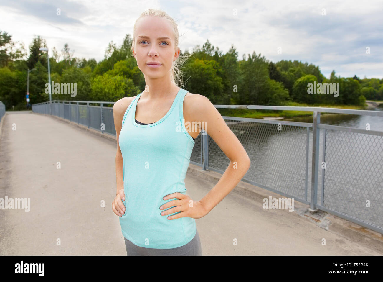 Selbstbewusste Frau steht an der Brücke nach Training Stockfoto