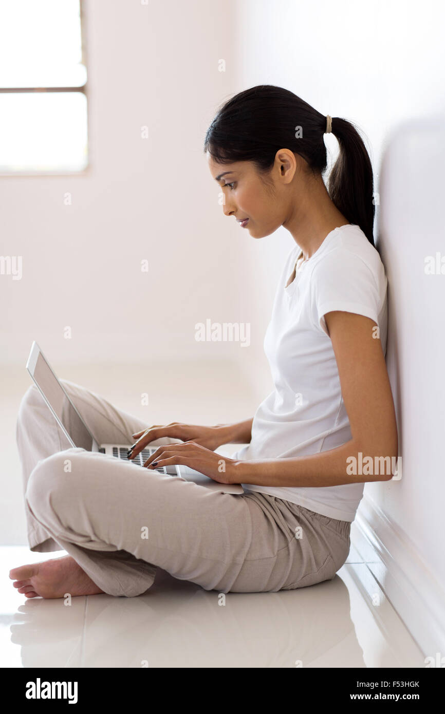 moderne indische Frau arbeiten am Laptop in ihrem neuen Zuhause Stockfoto