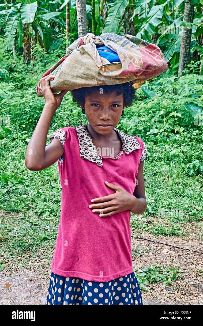 Junge Frau tragen Lasten auf dem Kopf Kiriwina PNG Stockfoto