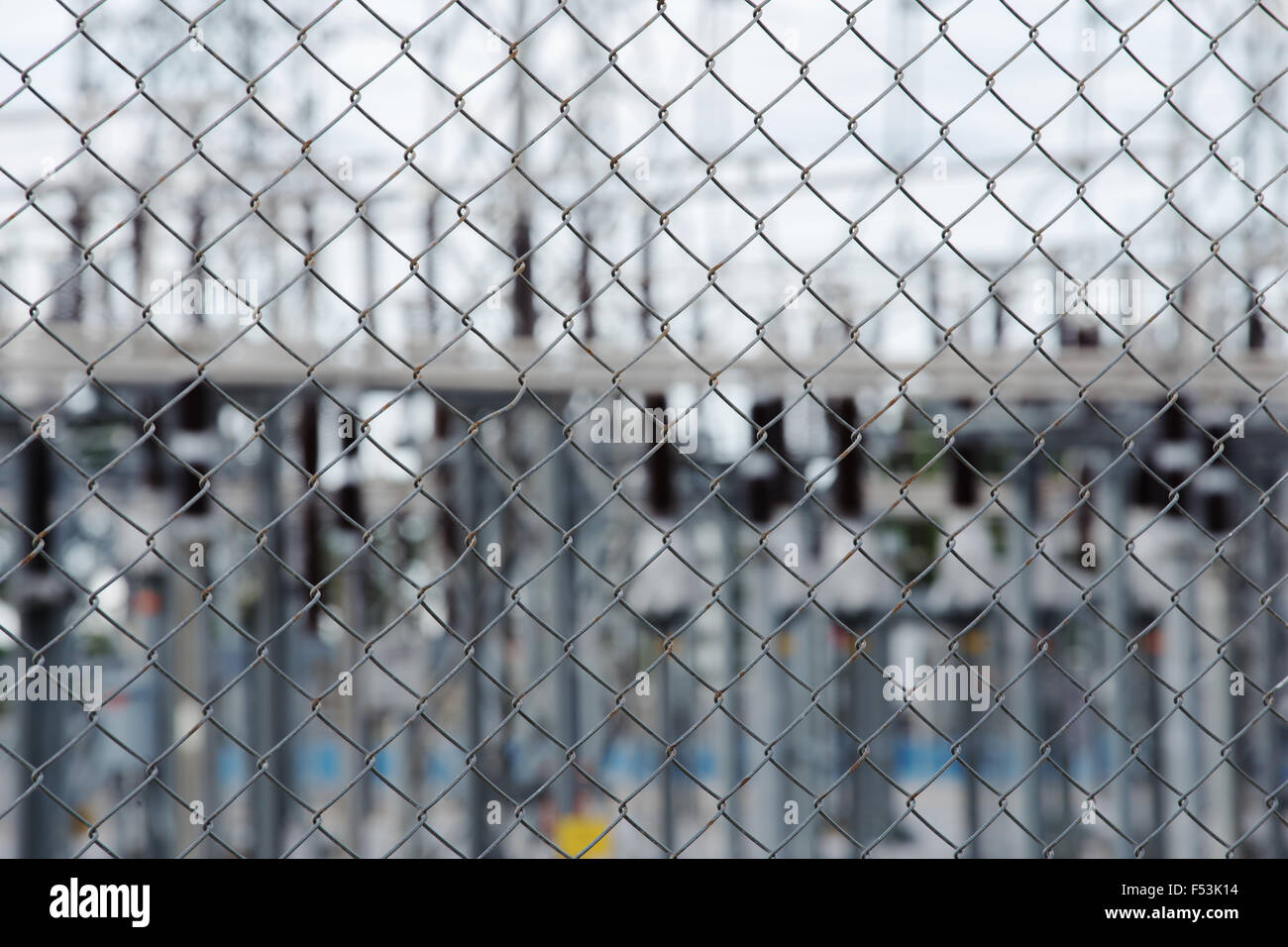 Metall-Draht-Zaun oder Käfig mit Hochspannung Strom Umspannwerk Hintergrund Stockfoto