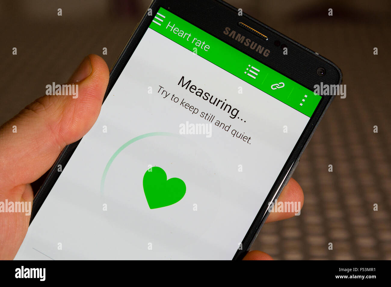 LONDON, VEREINIGTES KÖNIGREICH. Ein Samsung Smartphone Messung der Herzfrequenz des Benutzers sein. Stockfoto