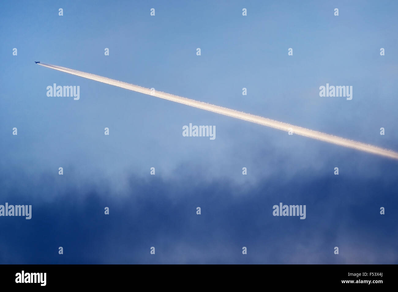 Flugzeug-Kondensstreifen sind am Himmel bei Sonnenuntergang gesehen. Stockfoto