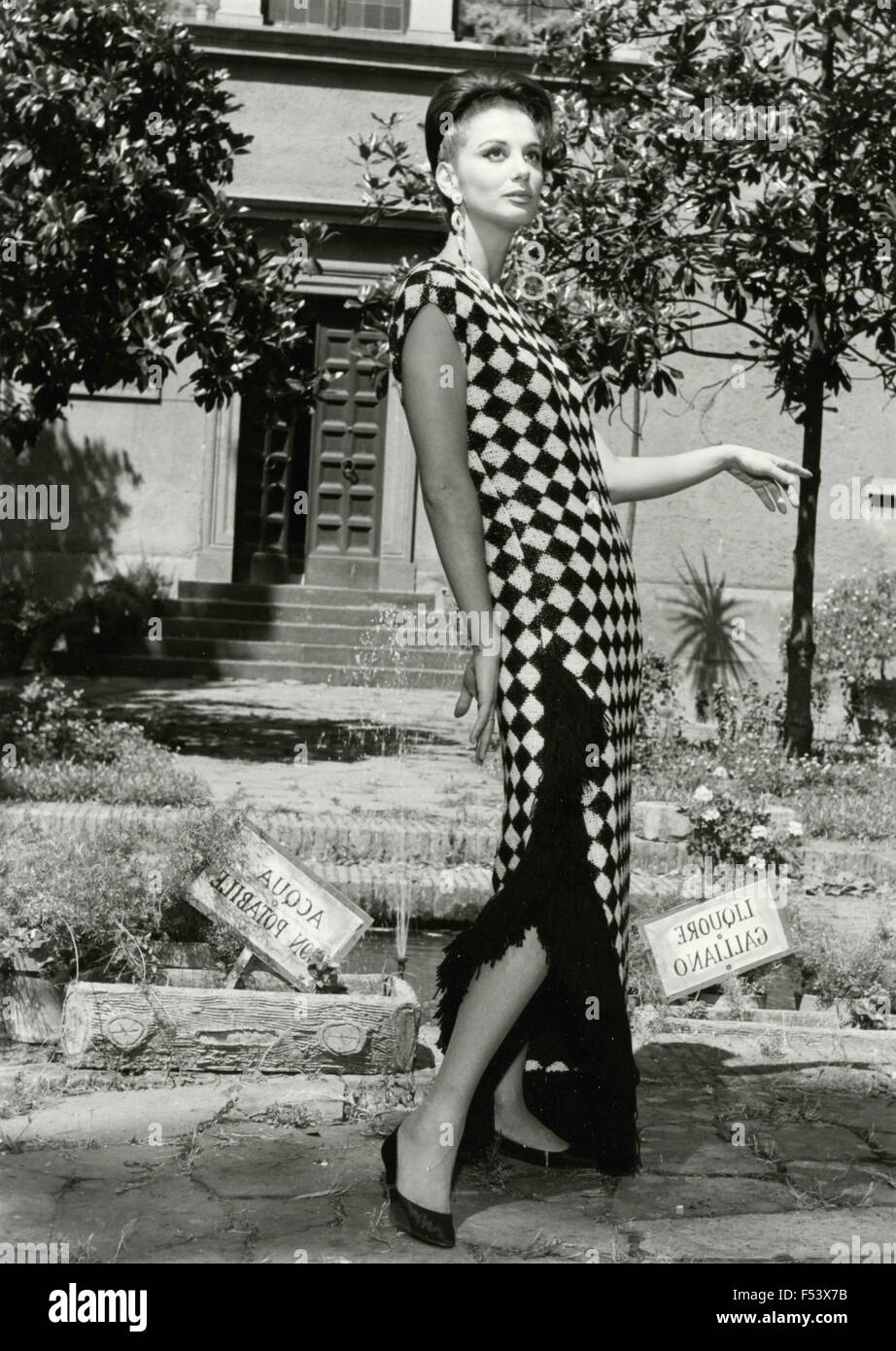 Ein Modell stellt eine Kleid auf einem Hintergrund von Zeitungen, Italien gemacht Stockfoto