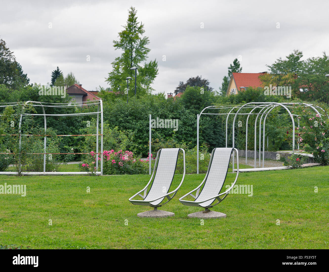 zwei stationäre Stühle für Erholung im Freien vor Rosengarten Stockfoto