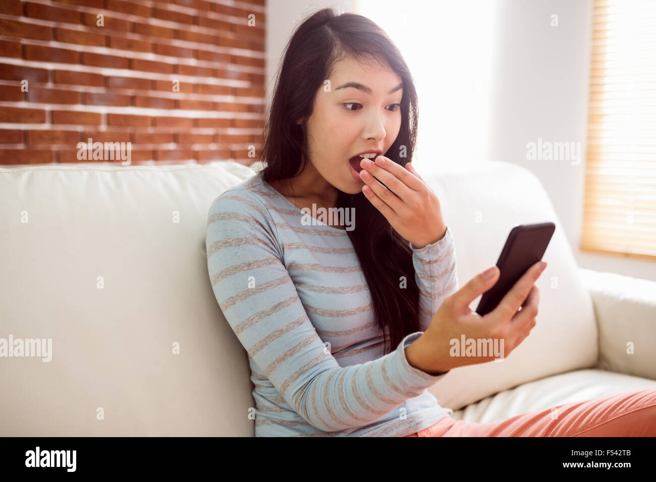 Asiatische Frau schockierenden Text zu lesen Stockfoto