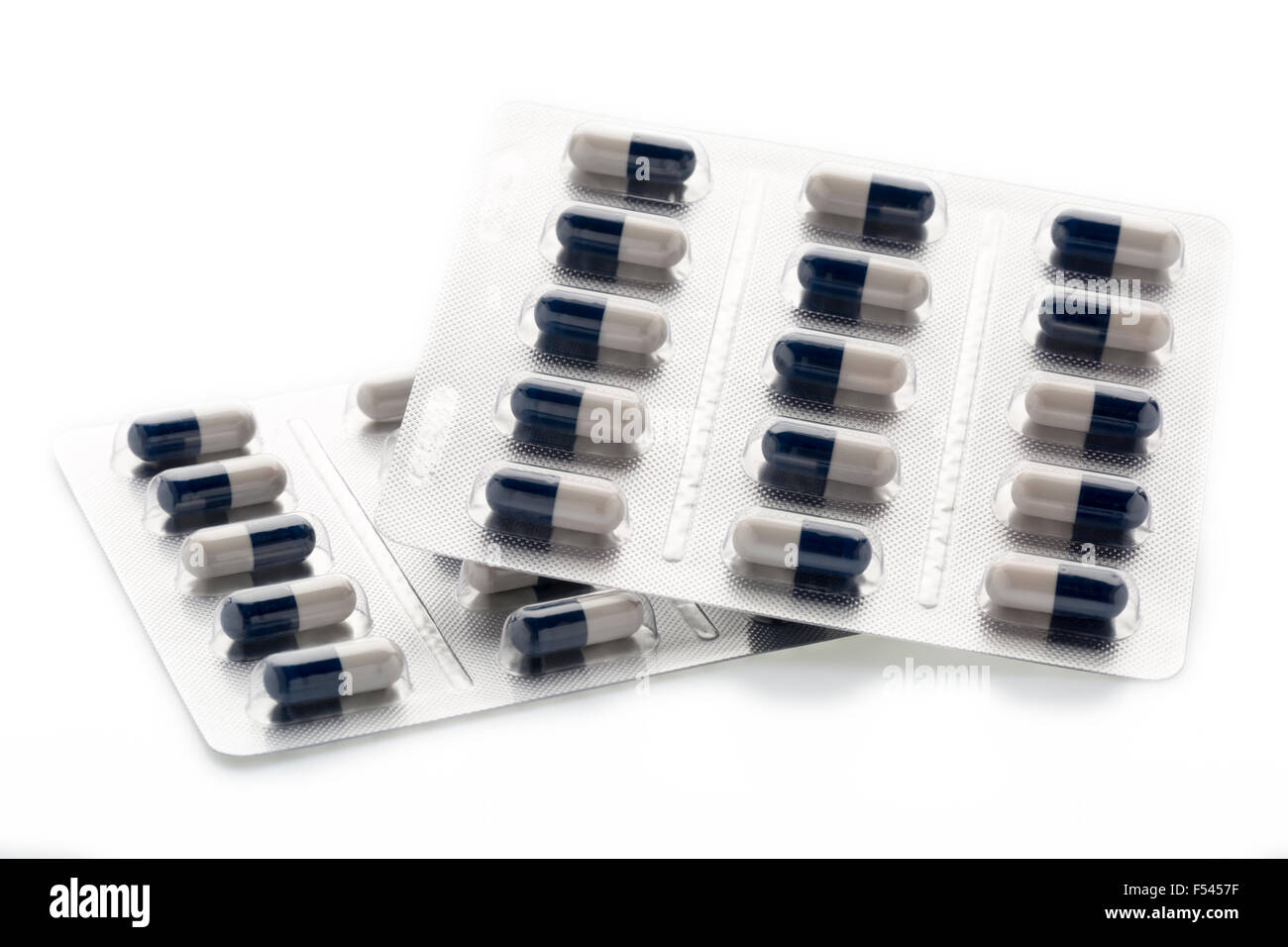 Dunkel blau-weiße Kapseln in Blister-Packungen Medikamente auf weißem Hintergrund Stockfoto