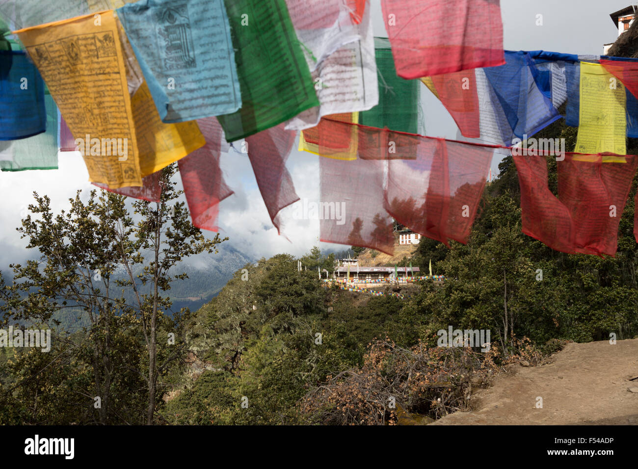 Gebetsfahnen und Gebäude auf Weg zur Tiger Nest Kloster, Paro, Bhutan Stockfoto