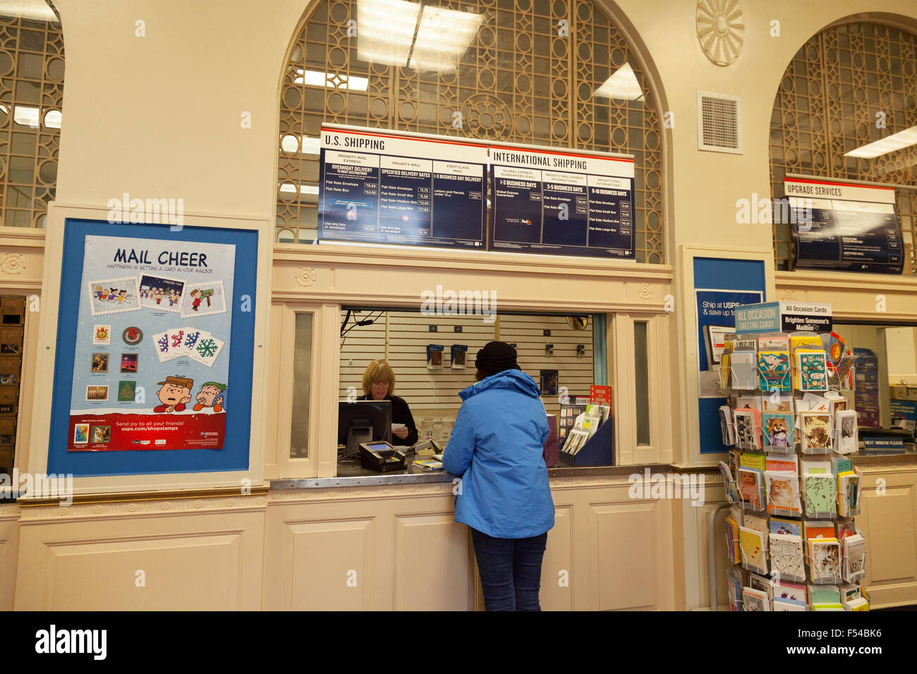 Eine Frau, die den Kauf von Briefmarken im Inneren eines US Post Office, New Hampshire USA Stockfoto