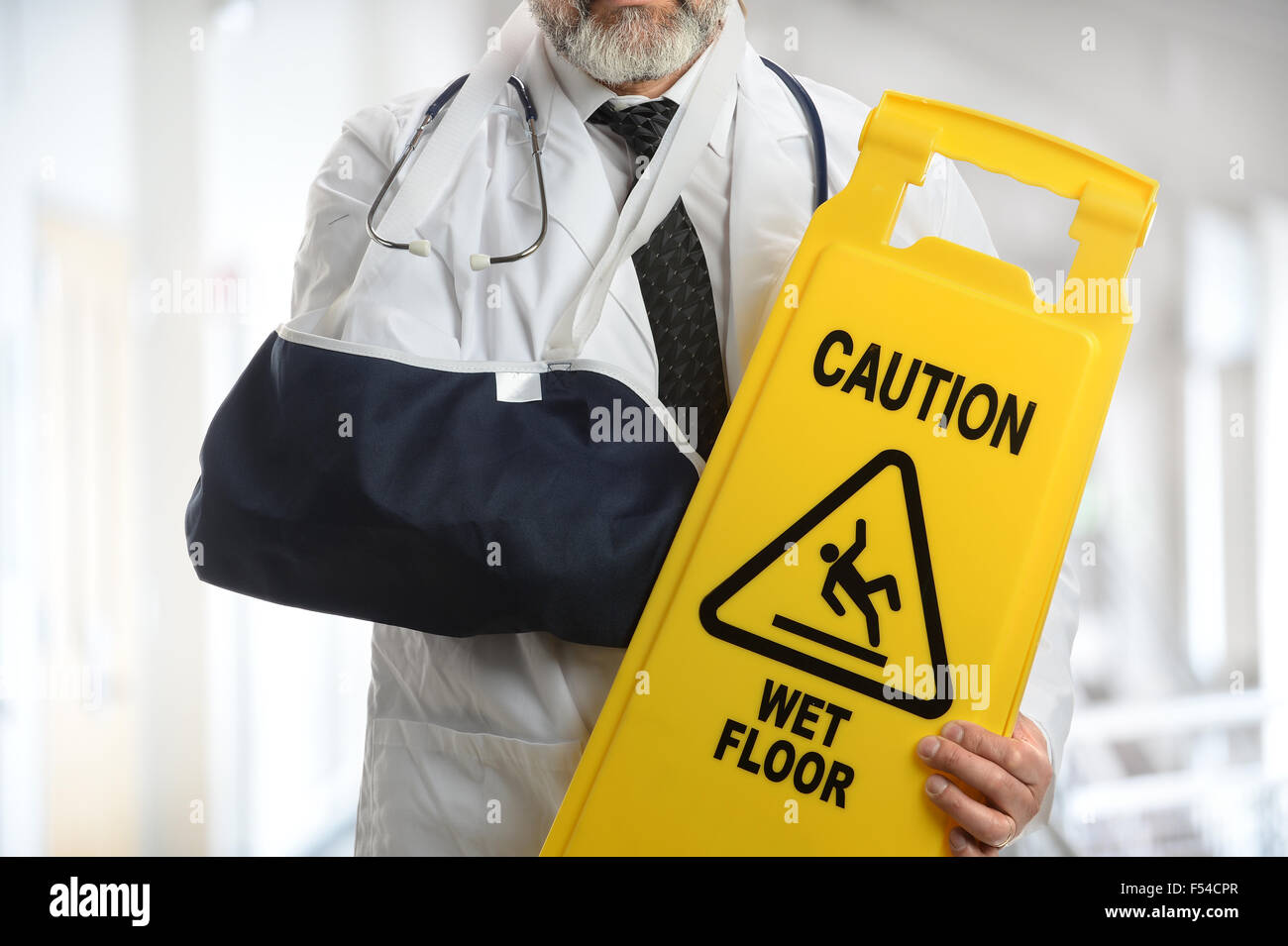 Leitender Arzt mit Vorsicht Schild während des Tragens Ellenbogen Schlinge Gebäudeinneren Stockfoto
