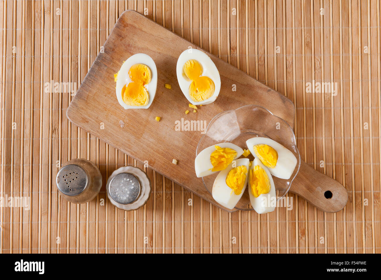 Schneiden Sie zwei Eigelb Ei mit Salz und Pfeffer, Doppel-Dotter und ein Eigelb Eiern Vergleich seltene Situation, Essen auf altem Holz liegend Stockfoto