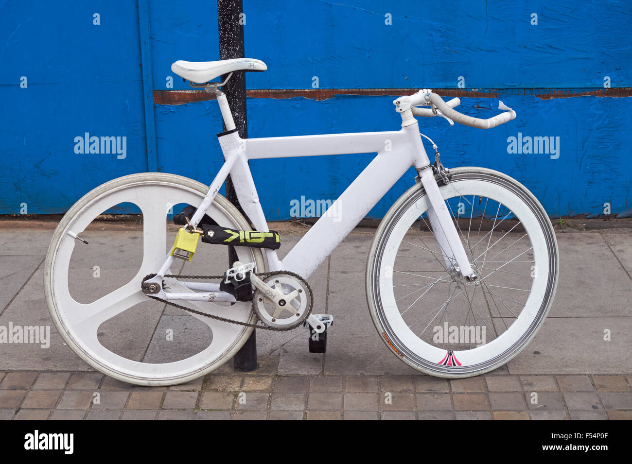 Weißen Fahrrad mit blauen Wand im Hintergrund, London England Vereinigtes Königreich UK Stockfoto