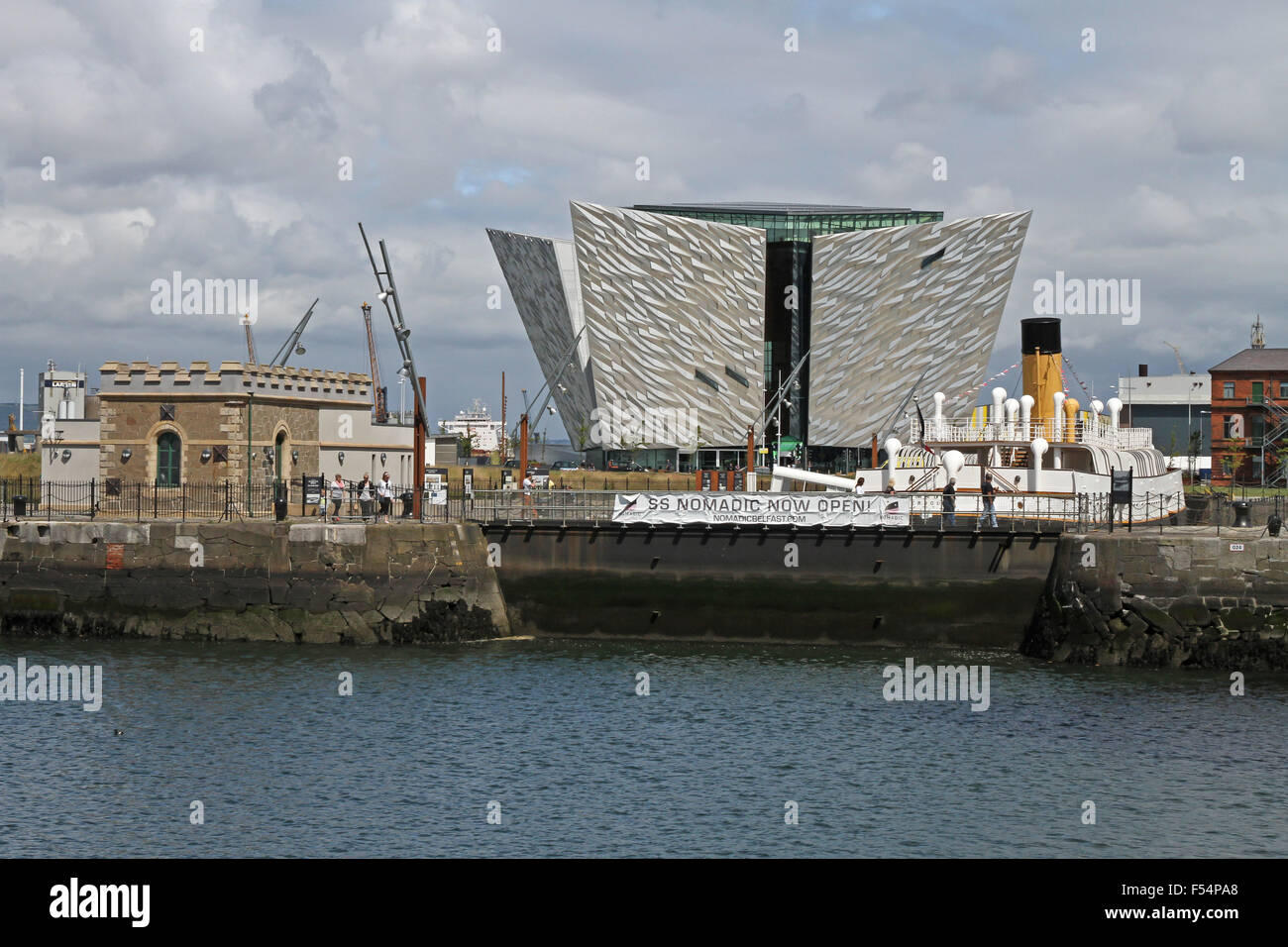 Die SS Nomadic in Hamilton Dock, Belfast mit der Titanic Besucherzentrum im Hintergrund. Stockfoto