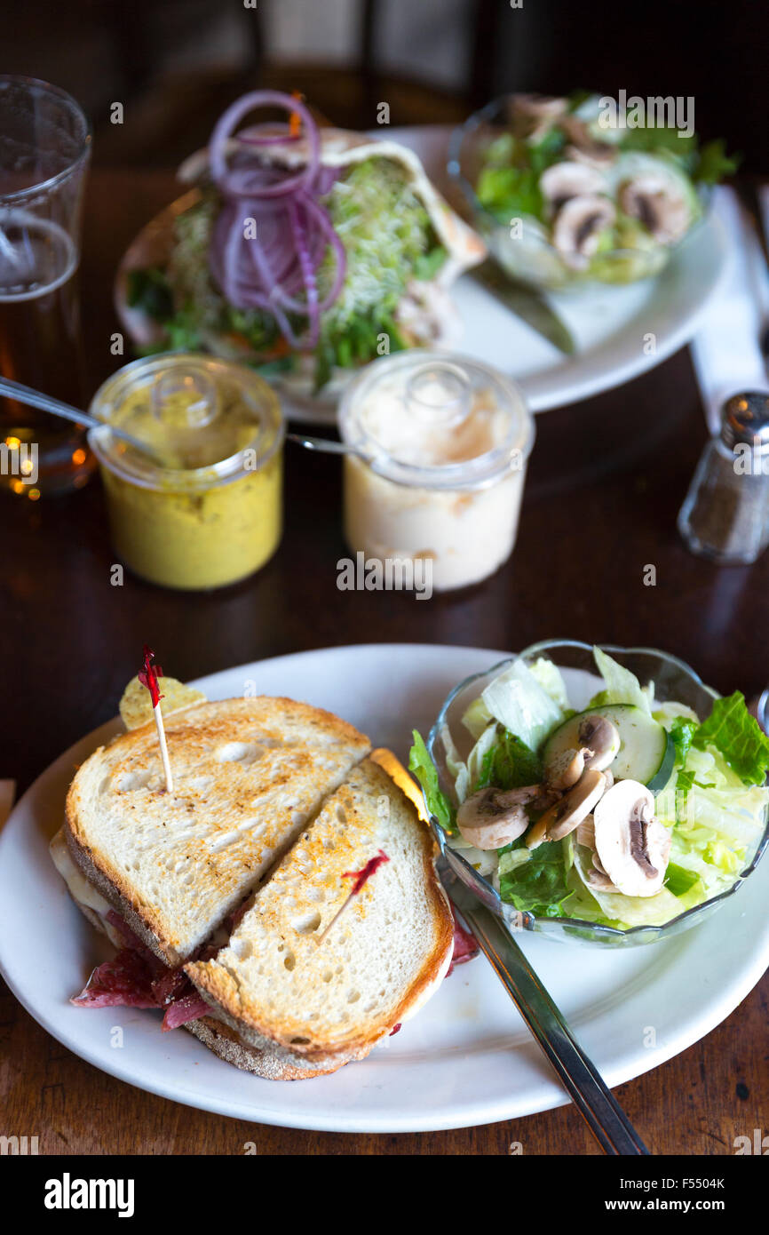 Riesige Deli Brot Sandwich mit Senf und Salat in bar Diner Restaurant in Soho, New York, USA Stockfoto
