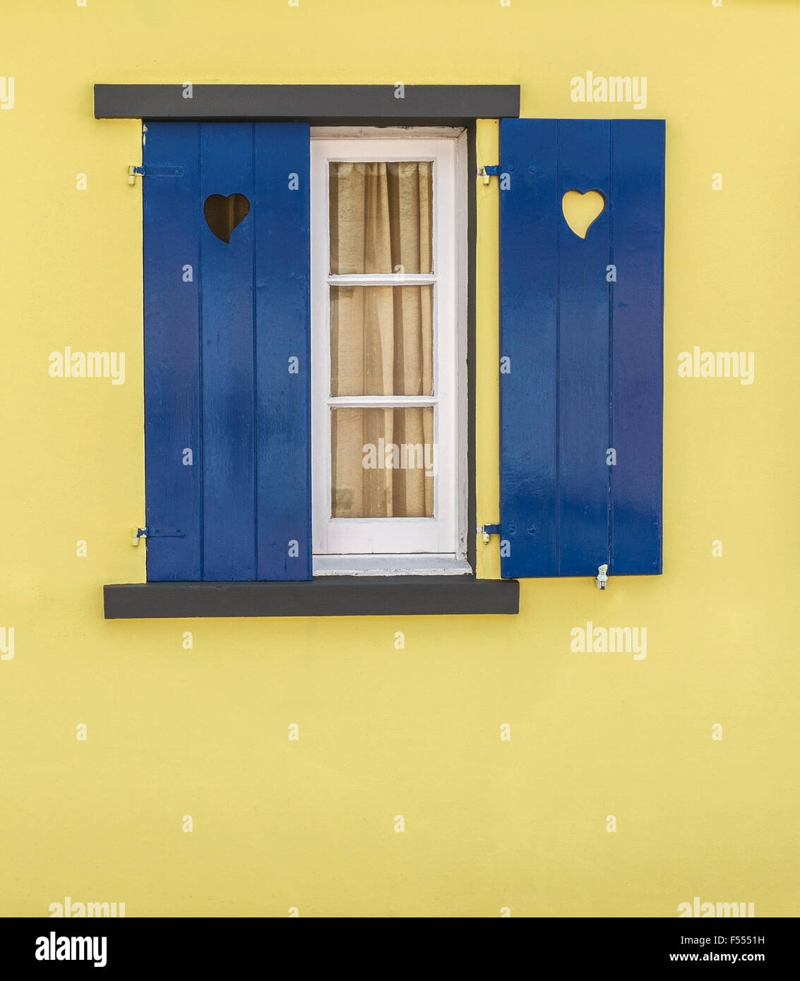 Detail von blue Window mit Herzen und gelbe Wand. Komplementärfarben. Stockfoto