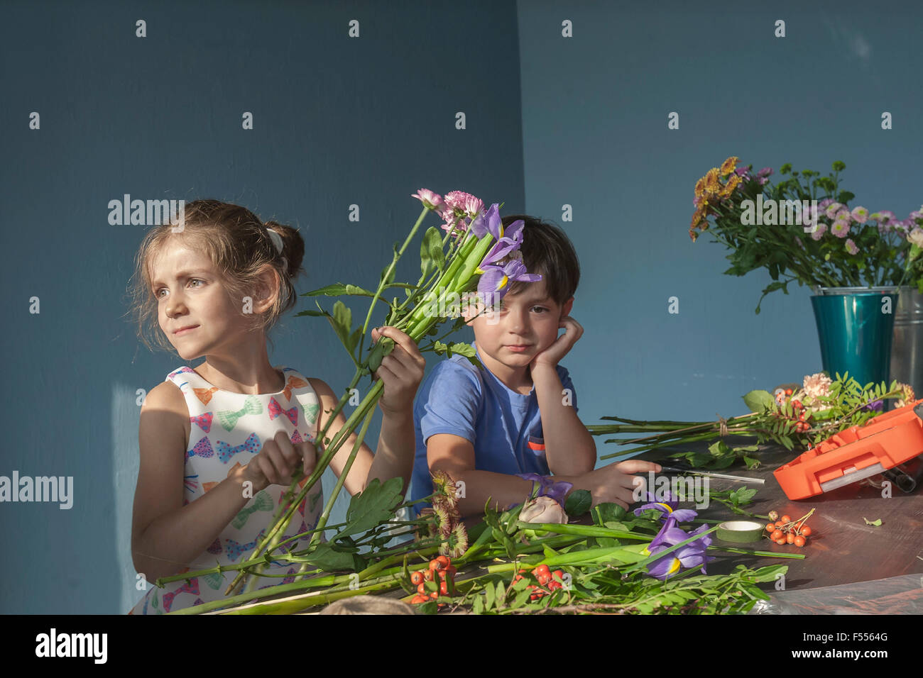 Geschwister, die Vermittlung von Blumen am Tisch Stockfoto