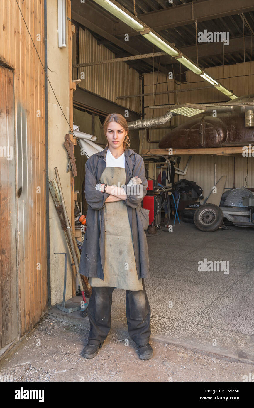 Porträt von zuversichtlich weibliche Mechaniker stehend Arme gekreuzt in der garage Stockfoto