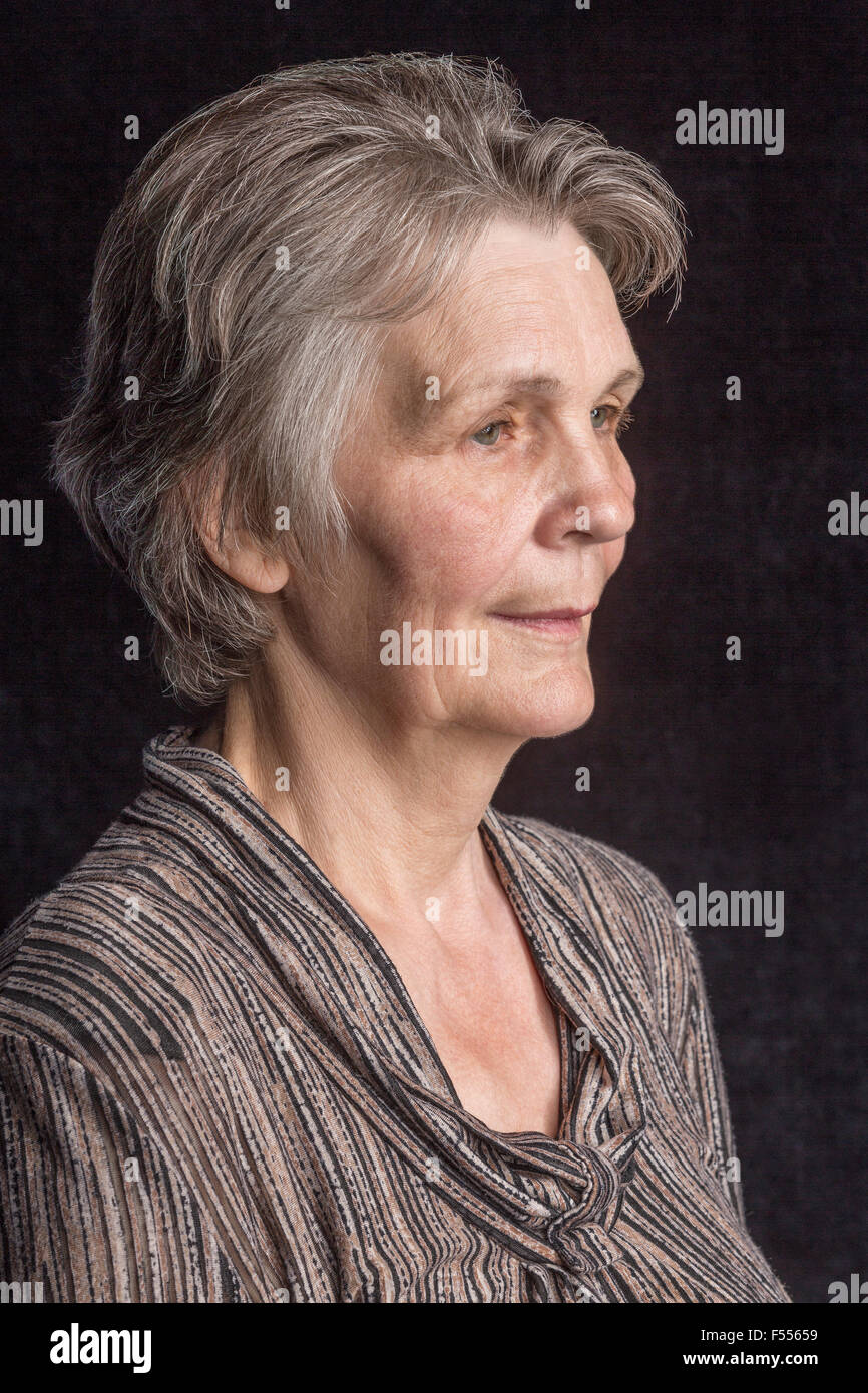 Nachdenklich senior Frau vor schwarzem Hintergrund Stockfoto
