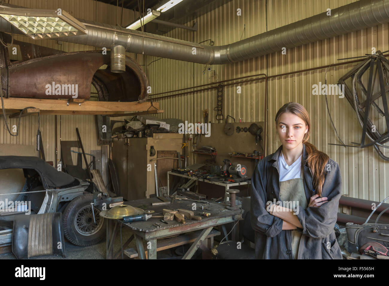 Porträt von zuversichtlich weibliche Mechaniker mit verschränkten in Werkstatt Stockfoto
